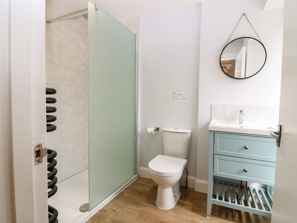 A bathroom with a shower, toilet, and sink at 21A High Street, Jedburgh