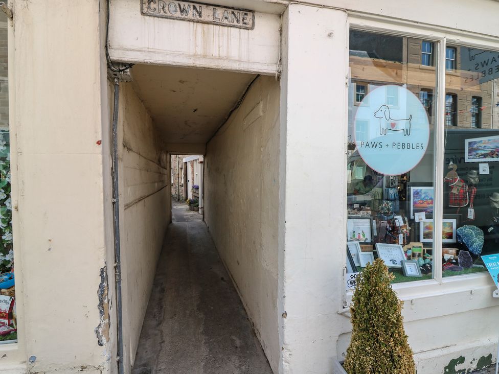 An alley with a shop window and a sign at 21A High Street in Jedburgh