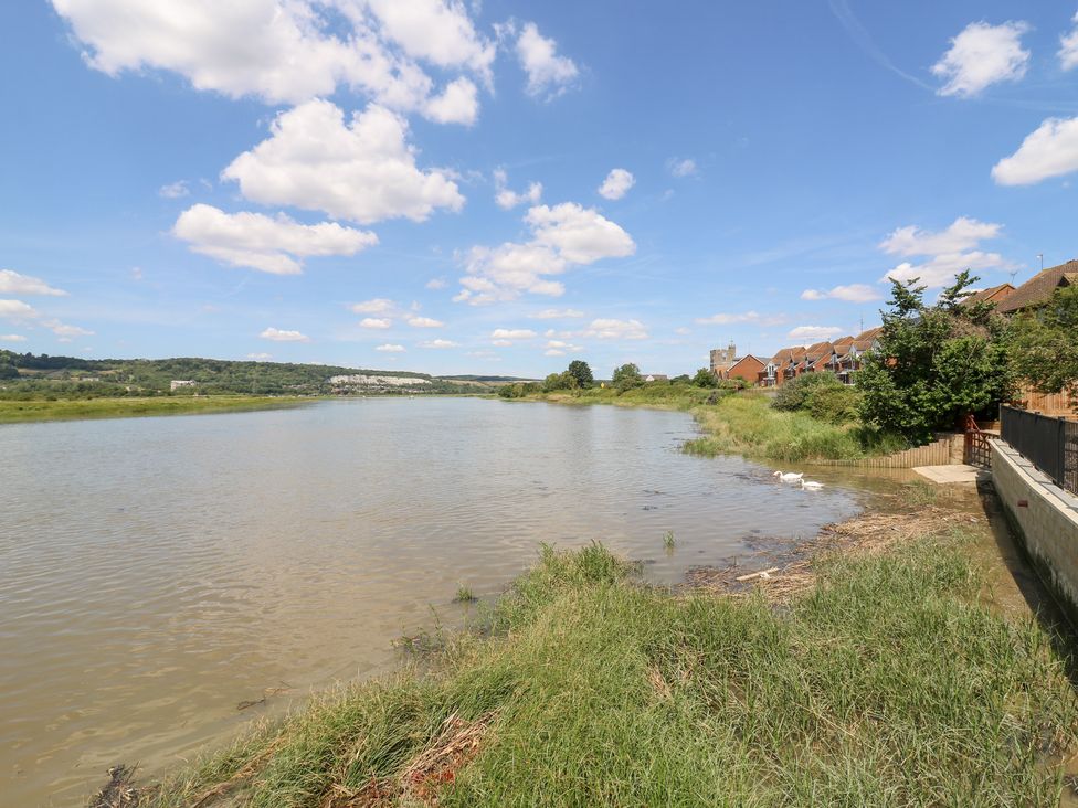 A river with grass and houses at Haymens Wharf in Wouldham