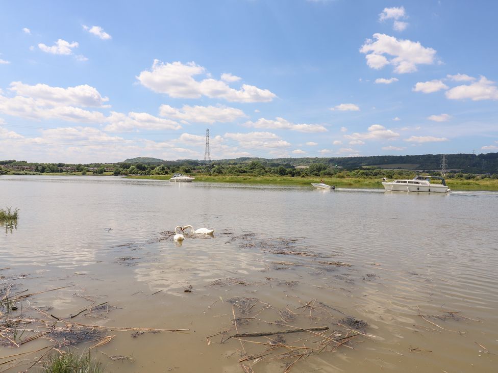 A river with swans and boats at Haymens Wharf in Wouldham