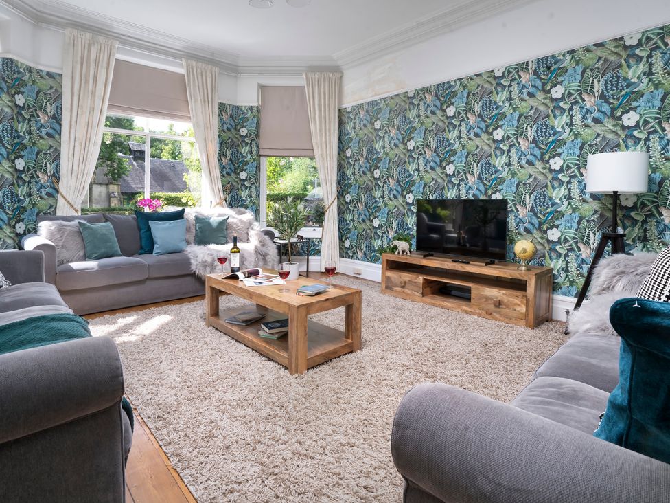 A living room with a sofa and television at Rosemount Boutique in Windermere