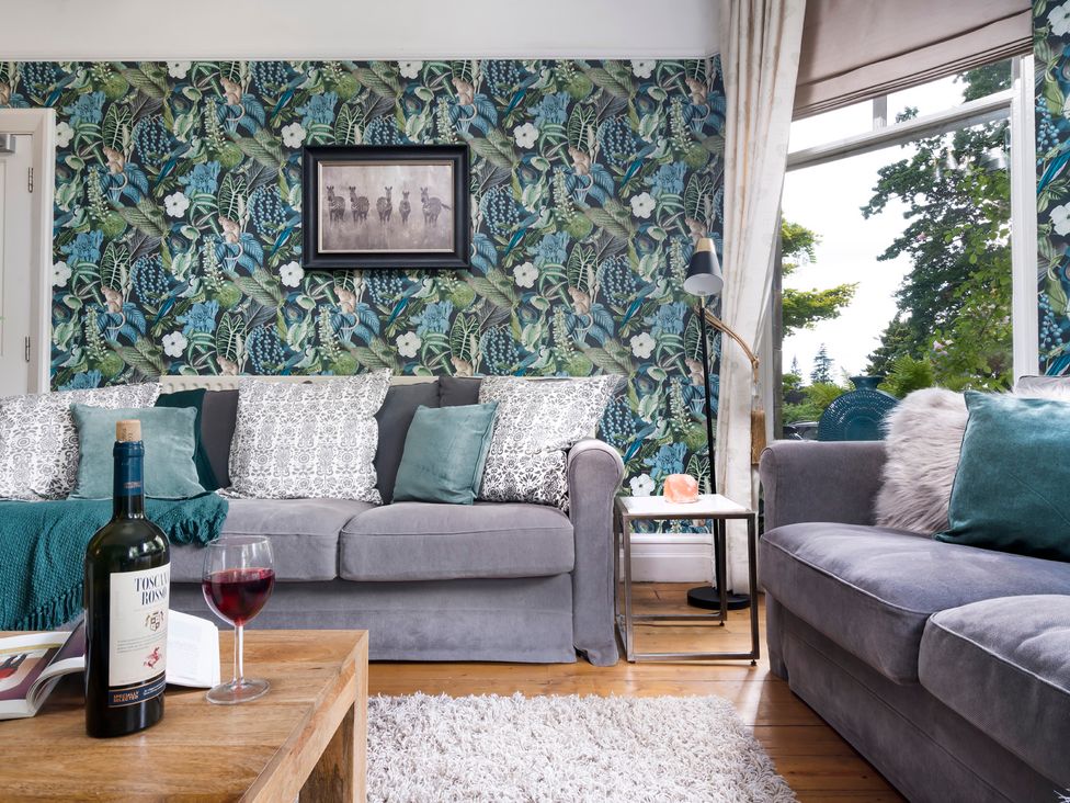 A living room with sofas and a wine bottle at Rosemount Boutique Windermere