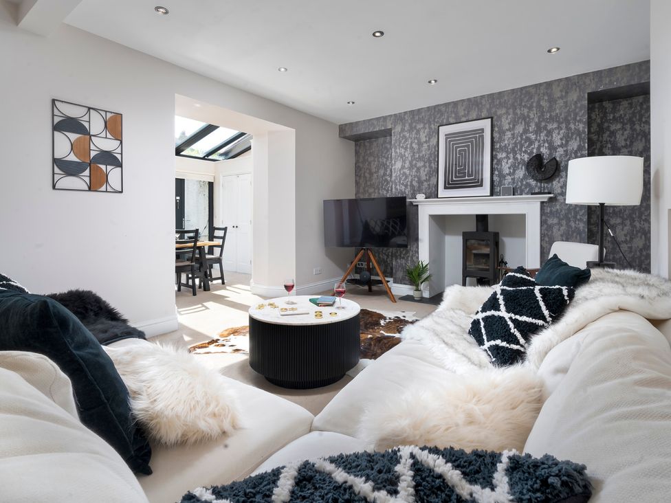 A living room with a coffee table and television at Rosemount Boutique in Windermere