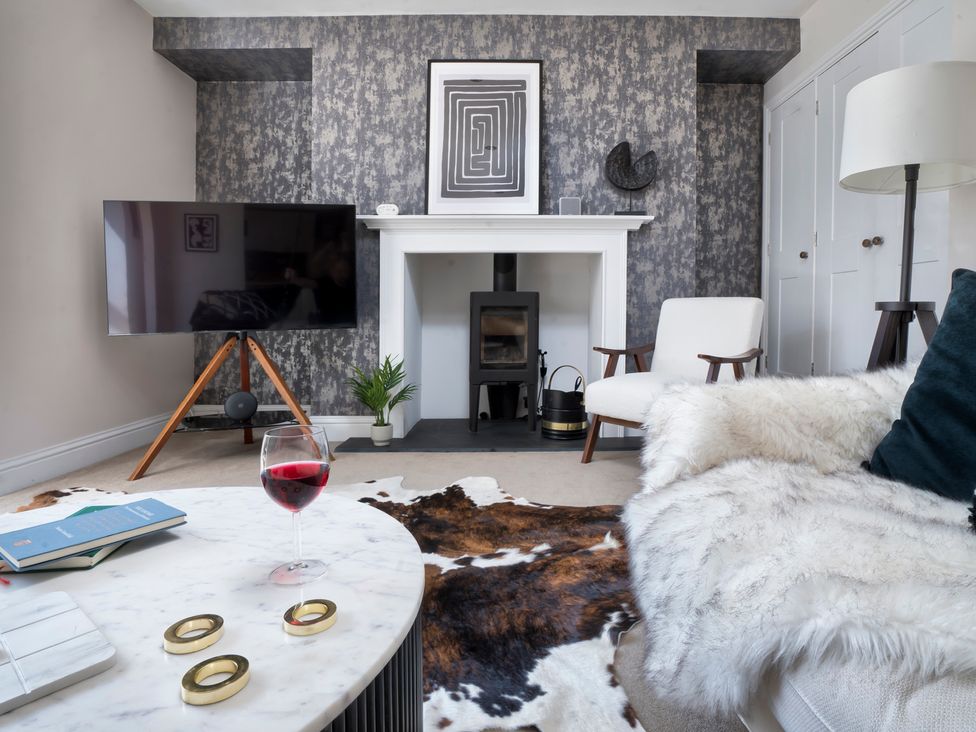 A living room with a television, coffee table, and fireplace at Rosemount Boutique in Windermere