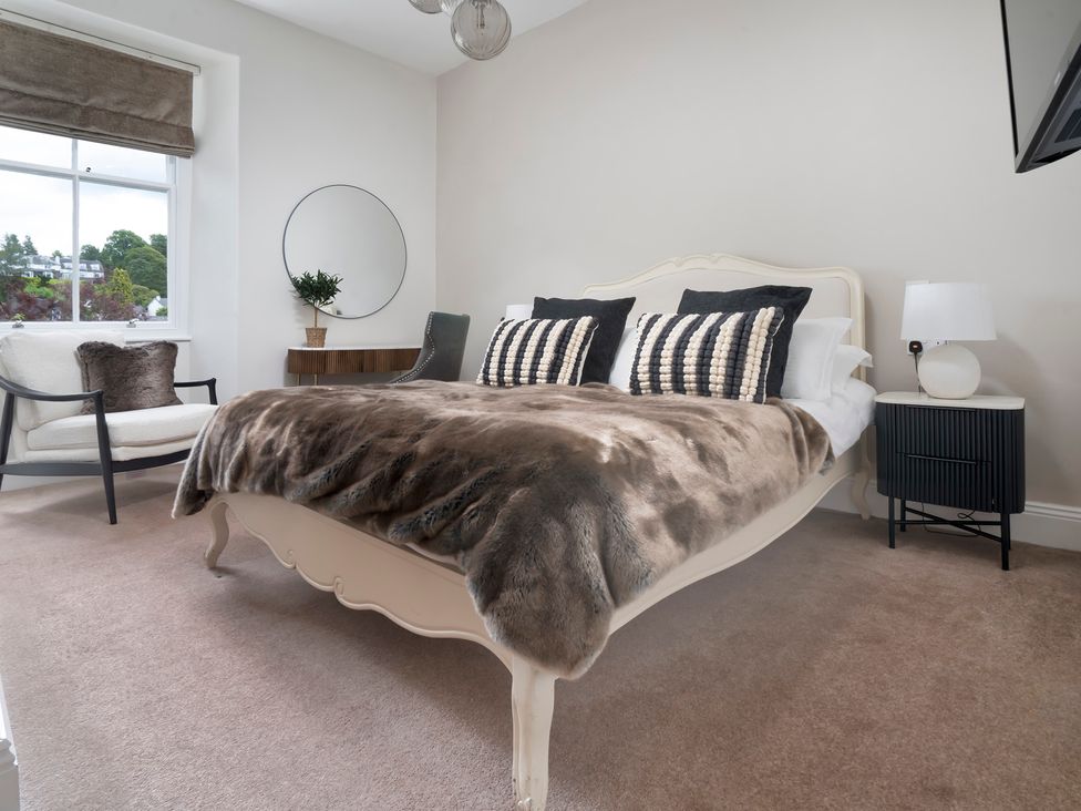 A bedroom with a bed and armchair at Rosemount Boutique, Windermere