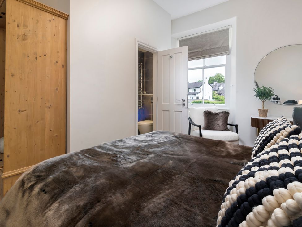 A bedroom with a bed and a wardrobe at Rosemount Boutique in Windermere