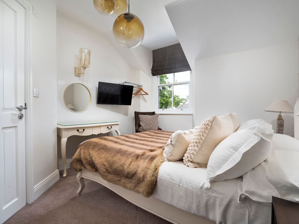 A bedroom with a bed and television at Rosemount Boutique in Windermere