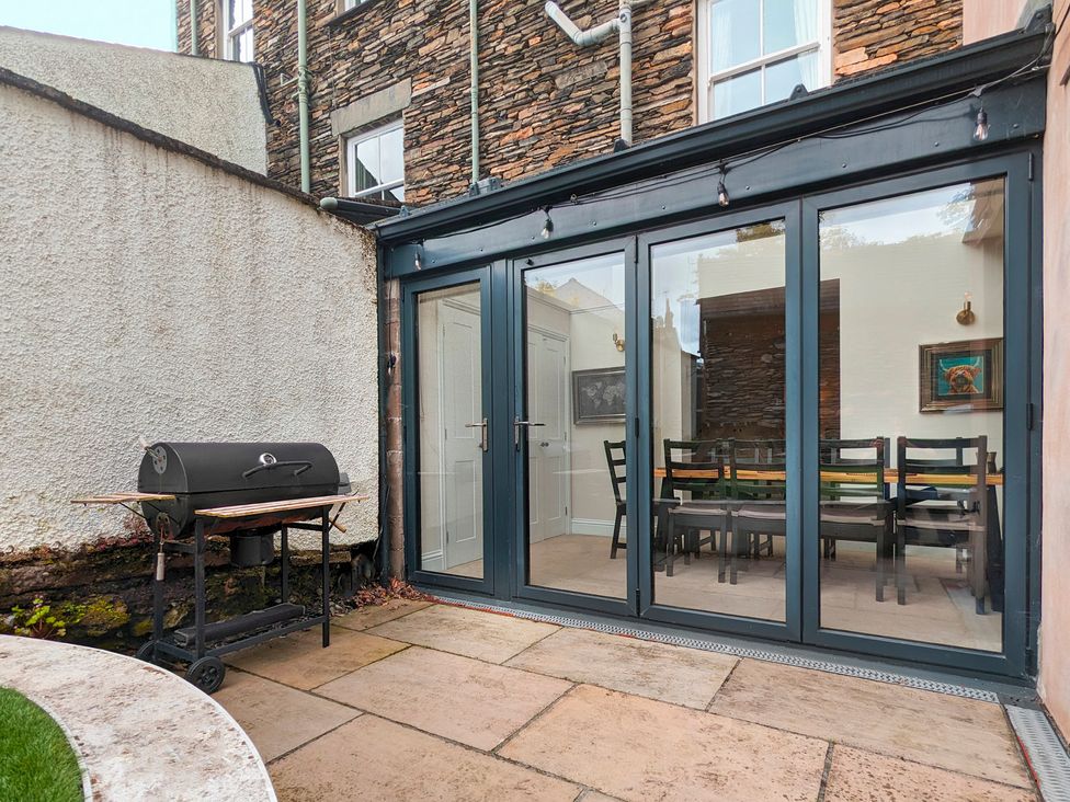 A dining room with glass doors and a grill outside at Rosemount Boutique in Windermere