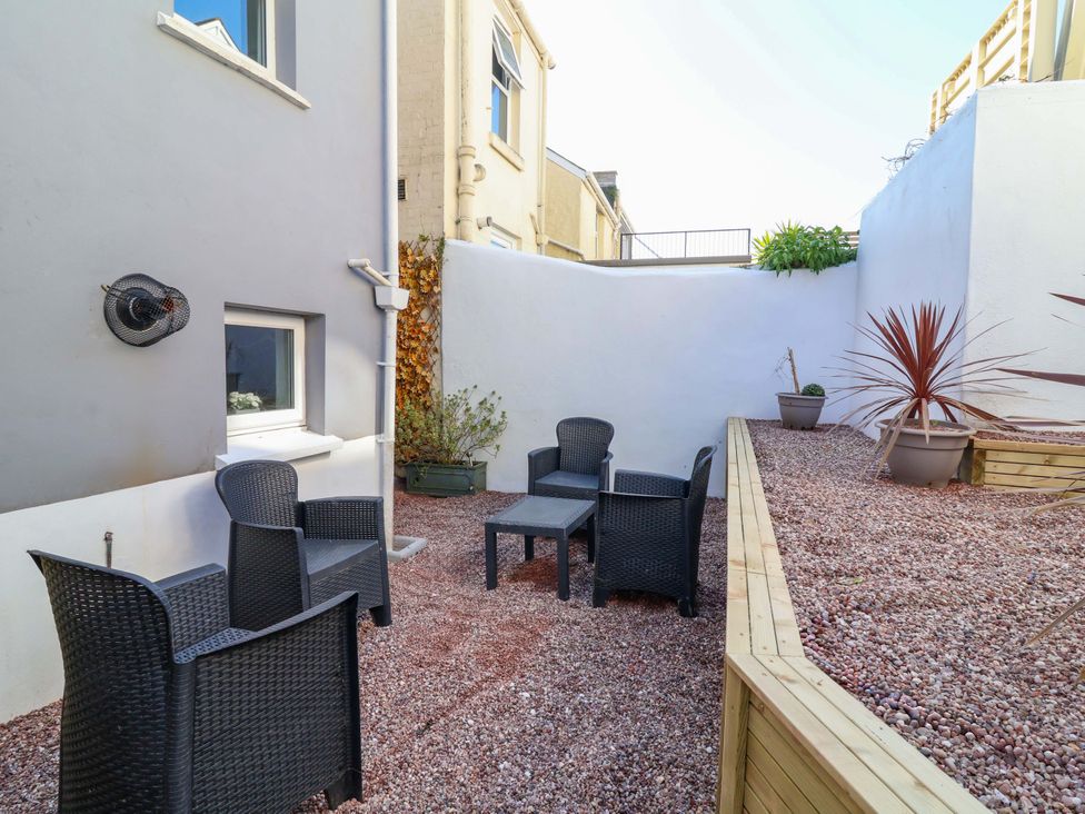 A garden with chairs and a table at Hollycombe in Ilfracombe