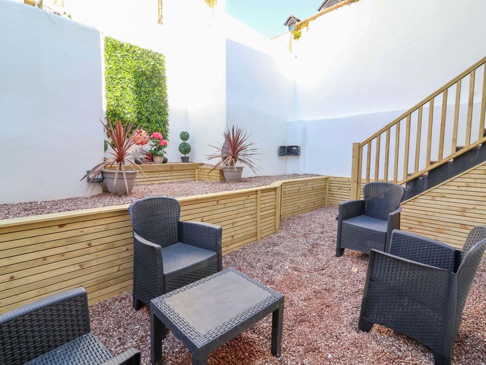 A garden with seating and planters at Hollycombe Ilfracombe