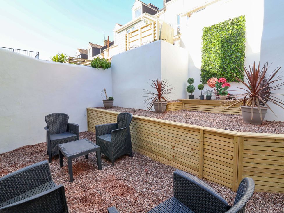 A garden with seating and planters at Hollycombe in Ilfracombe