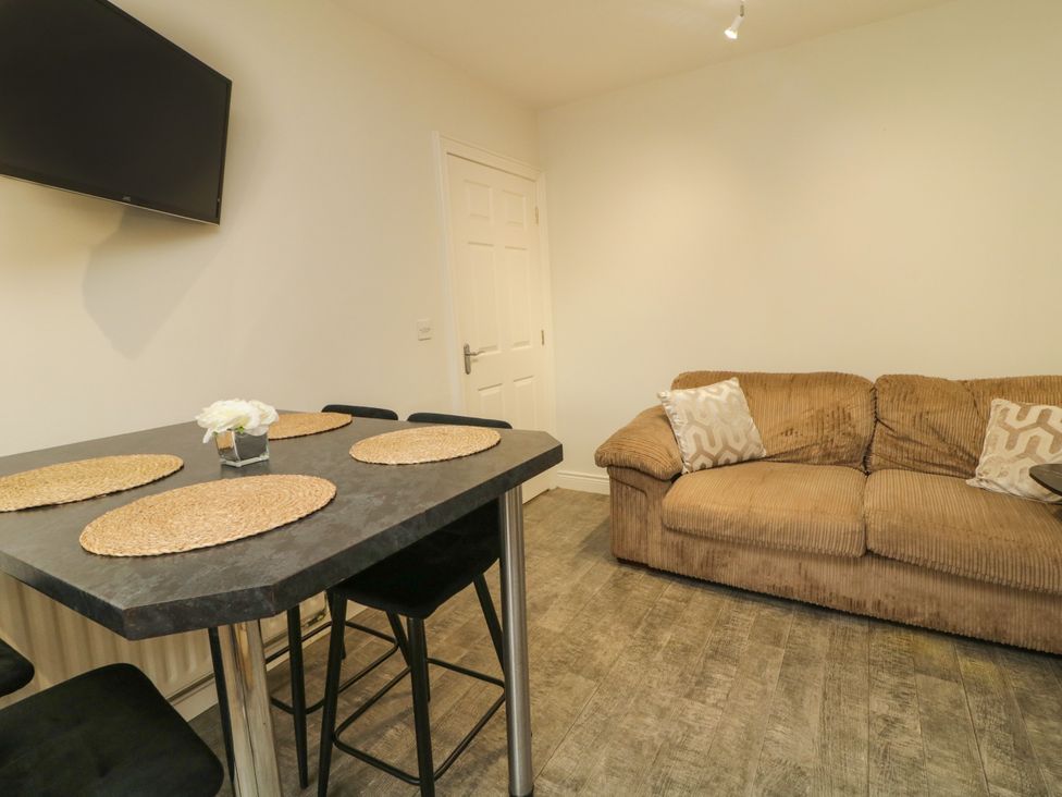 A living room with a table and sofa at Woodside Guest House in Castlerock