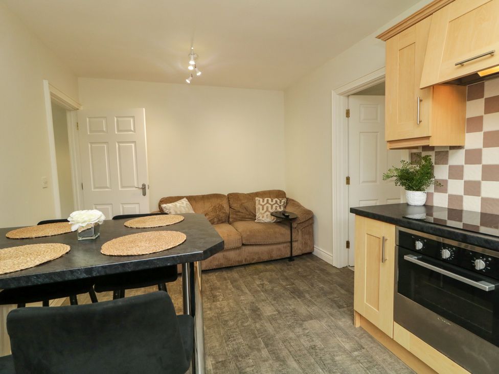 A kitchen with a dining area and sofa at Woodside Guest House in Castlerock