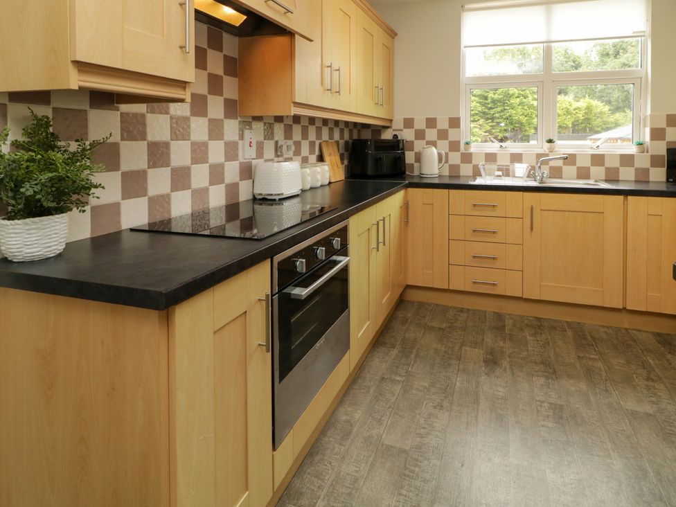 A kitchen with cabinets and a sink at Woodside Guest House Castlerock
