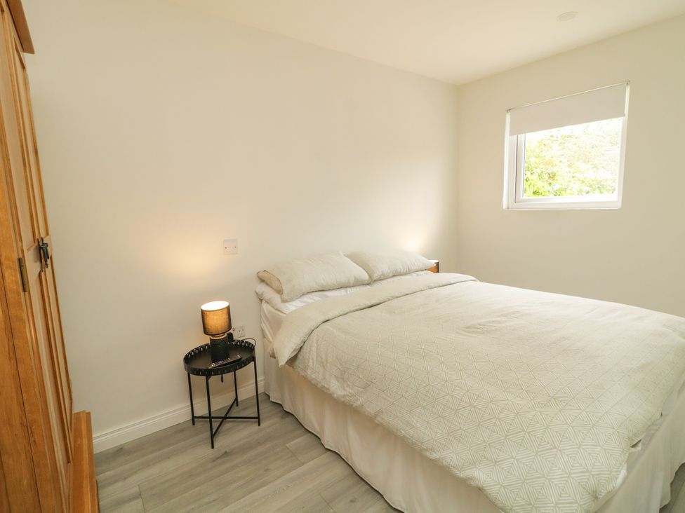 A bedroom with a bed and a wardrobe at Woodside Guest House in Castlerock