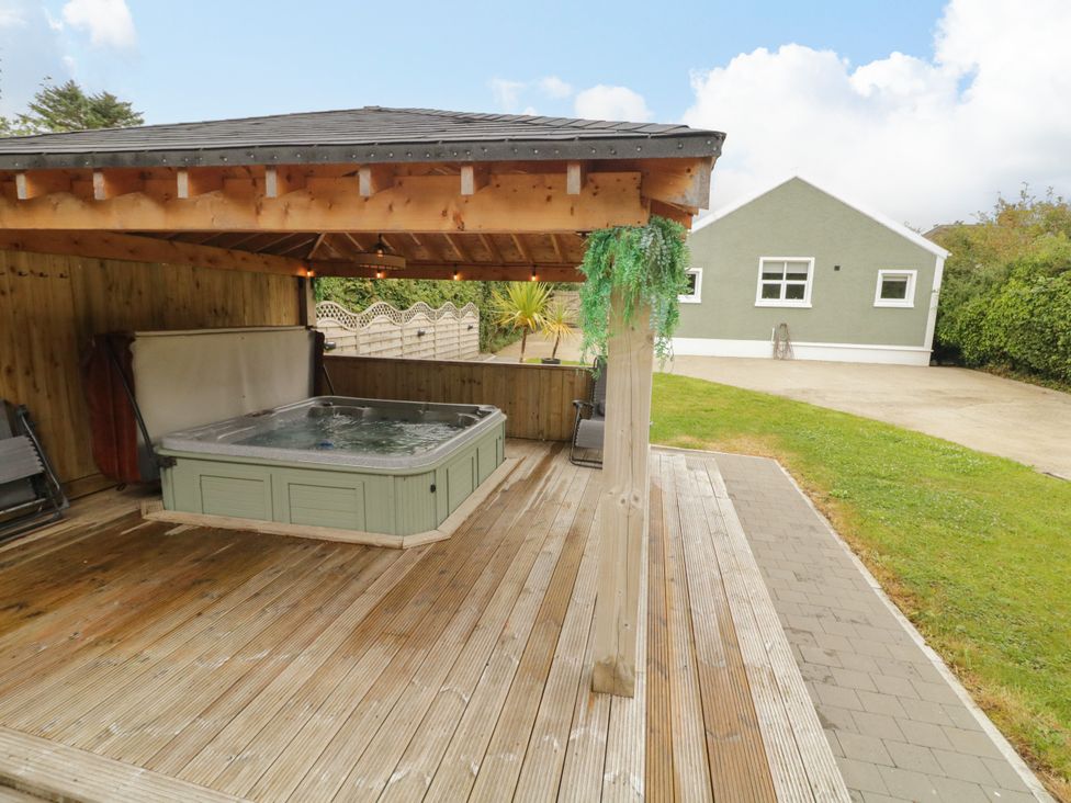 An outdoor area with a hot tub under a canopy at Woodside Guest House in Castlerock