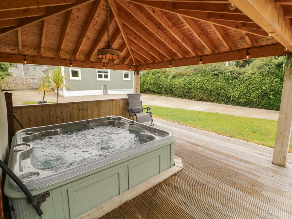 An outdoor area with a hot tub and decking at Woodside Guest House in Castlerock