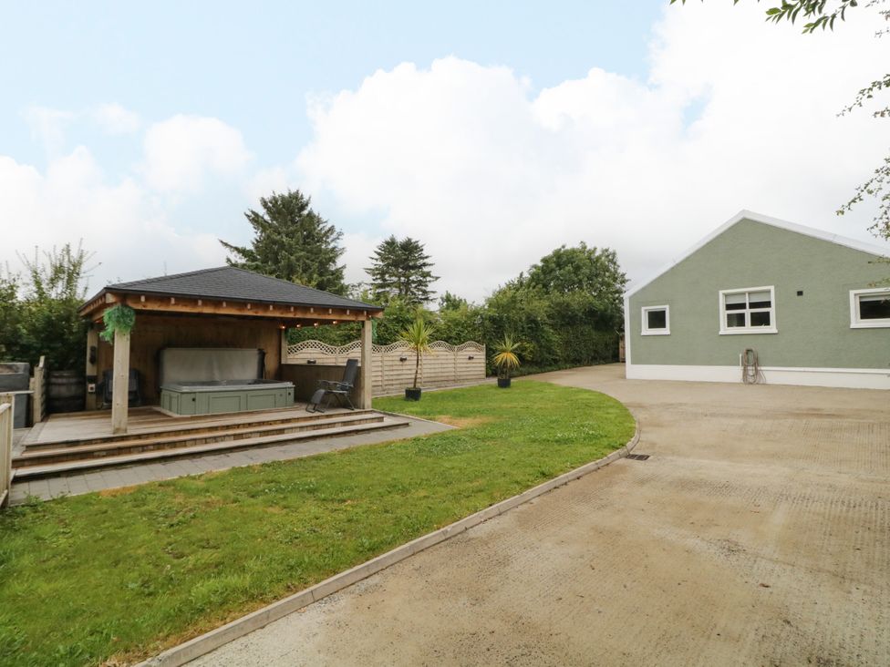 An outdoor area with a hot tub and seating at Woodside Guest House in Castlerock