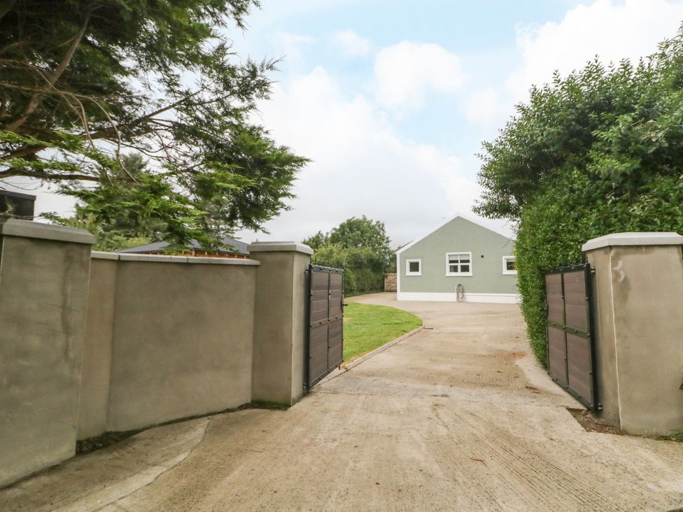 A house with a driveway and gate at Woodside Guest House in Castlerock