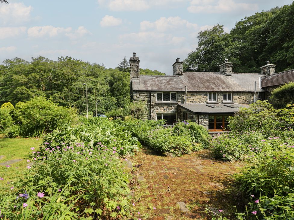 A cottage with a garden and stone pathway at Glandwr Cottage in Llanbedr