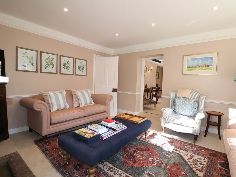 A living room with a sofa and an armchair at Rectory Cottage in Chawton near Alton, Hampshire