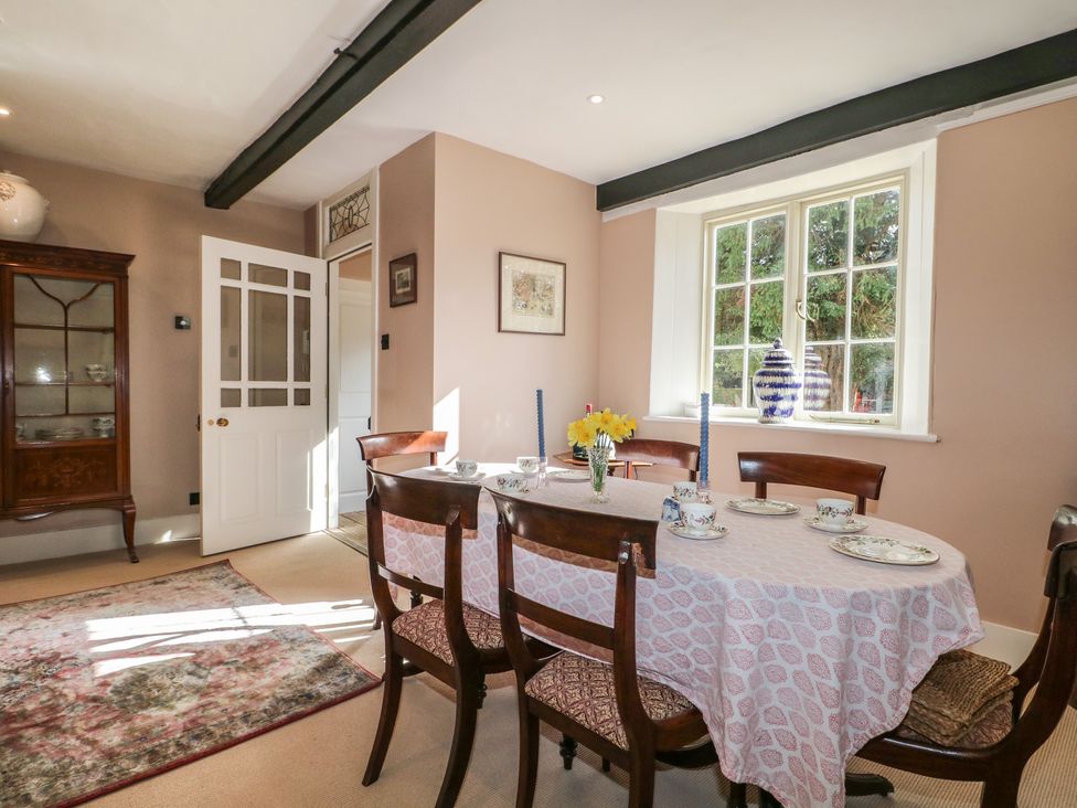 A dining room with a table set for meals at Rectory Cottage in Chawton near Alton, Hampshire