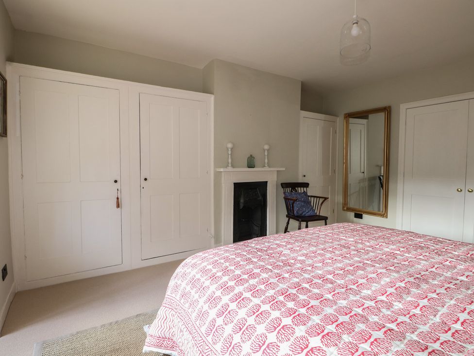 A bedroom with a bed and armchair at Rectory Cottage Chawton near Alton Hampshire