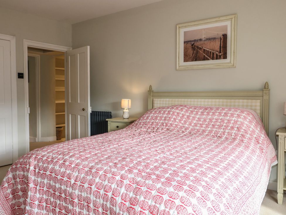 A bedroom with a bed and nightstand at Rectory Cottage in Chawton near Alton Hampshire