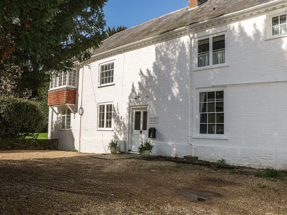 An exterior view of a building with a sign and plants at Rectory Cottage Chawton near Alton Hampshire