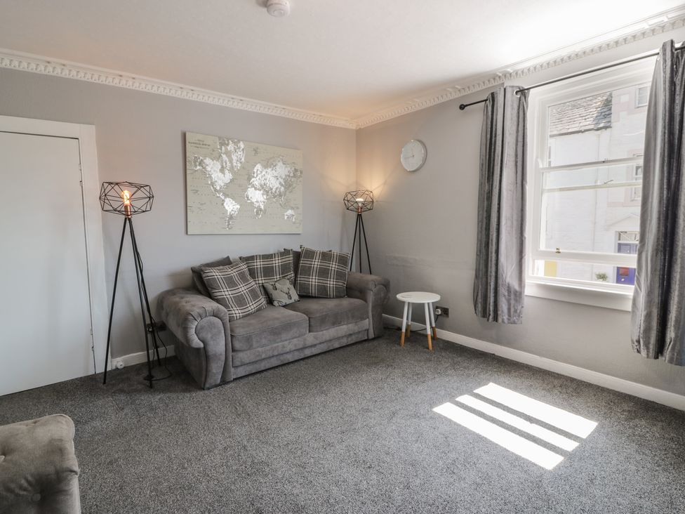 A living room with a sofa and a lamp at Fleet Townhouse in Castle Douglas