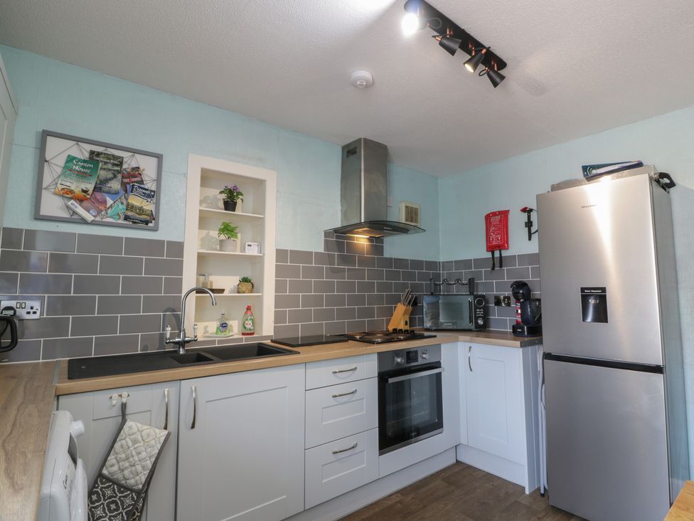 A kitchen with a refrigerator and cooking appliances at Fleet Townhouse in Castle Douglas