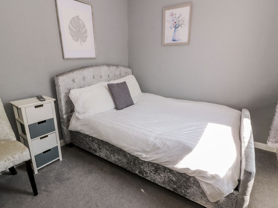 A bedroom with a bed and bedside table at Fleet Townhouse in Castle Douglas