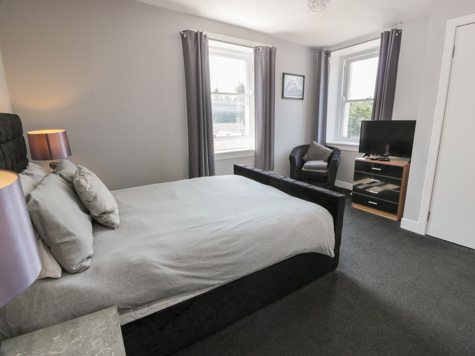 A bedroom with a bed and television at Fleet Townhouse in Castle Douglas