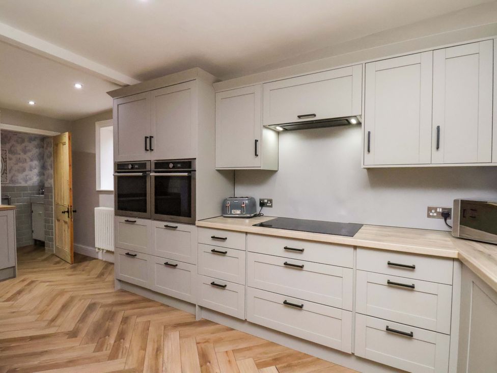 A kitchen with cabinets and appliances at 59 Moorland Road Scarborough
