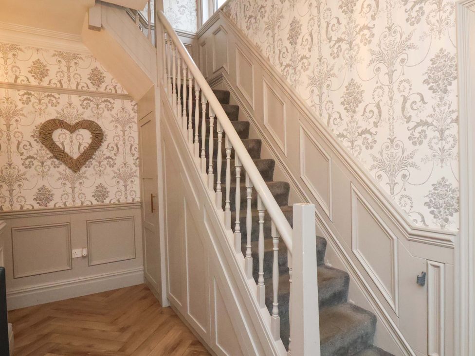 A hallway with a staircase and decorative wallpaper at 59 Moorland Road, Scarborough