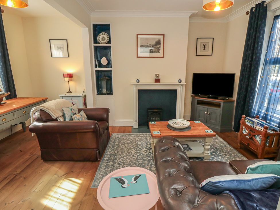 A living room with a sofa and television at 1 Albion Place Whitby