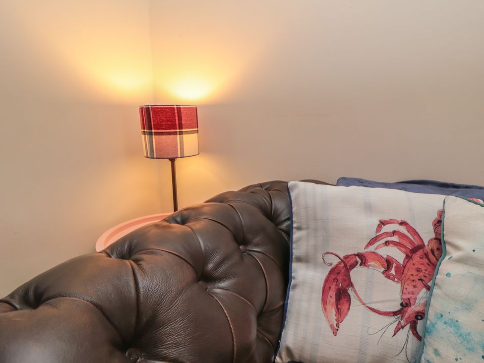A sofa with a lobster pillow and a lamp at 1 Albion Place in Whitby
