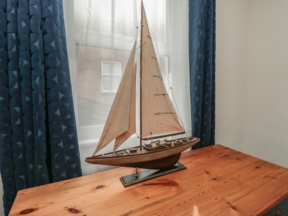 A model sailboat on a wooden table at 1 Albion Place in Whitby