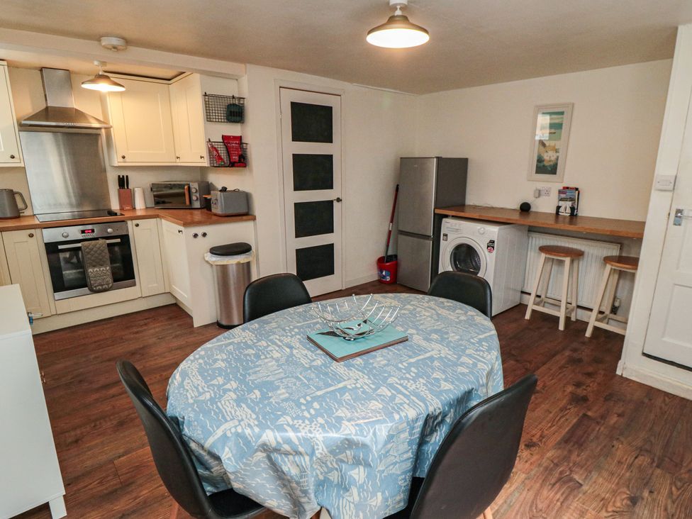 A kitchen with appliances and a dining table at 1 Albion Place Whitby