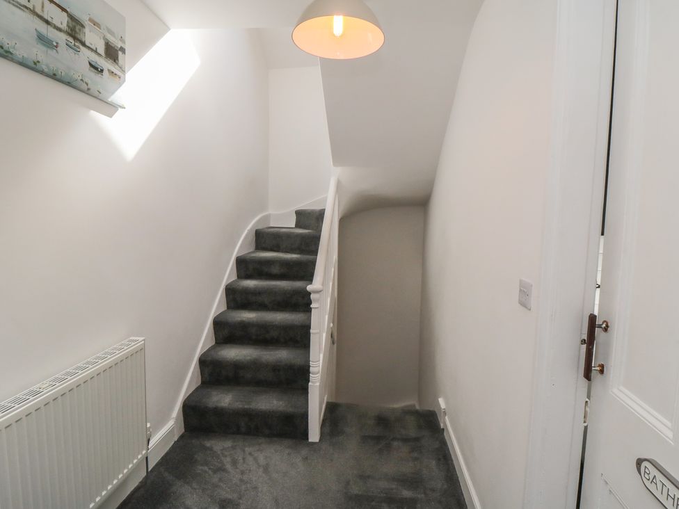 A hallway with a staircase and a door at 1 Albion Place in Whitby
