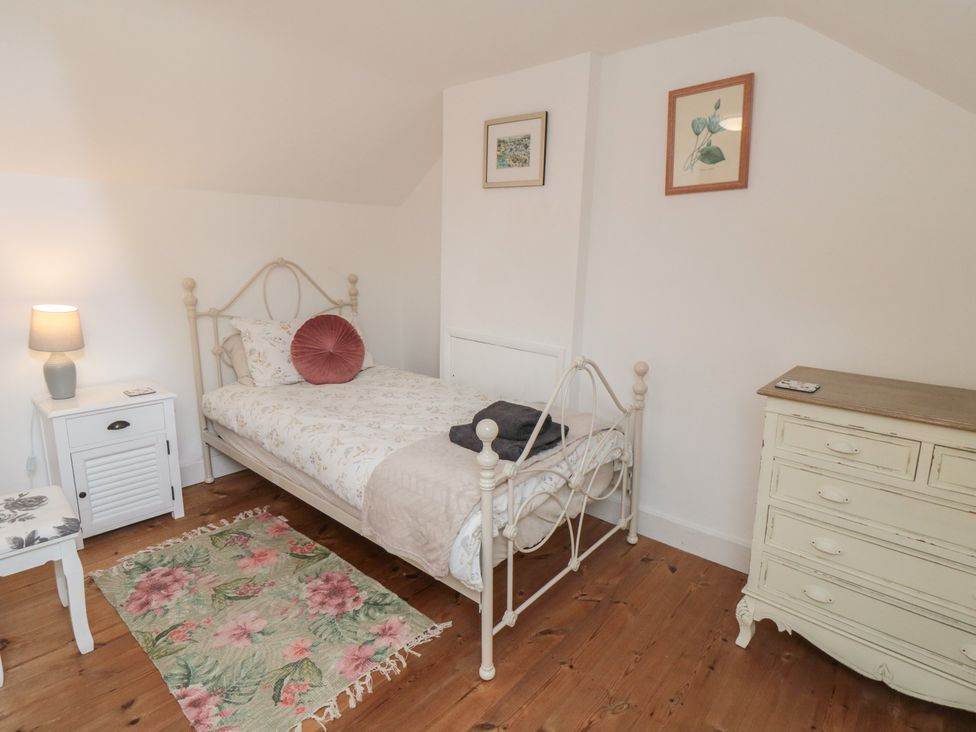 A bedroom with a bed, lamp, and dresser at 1 Albion Place, Whitby