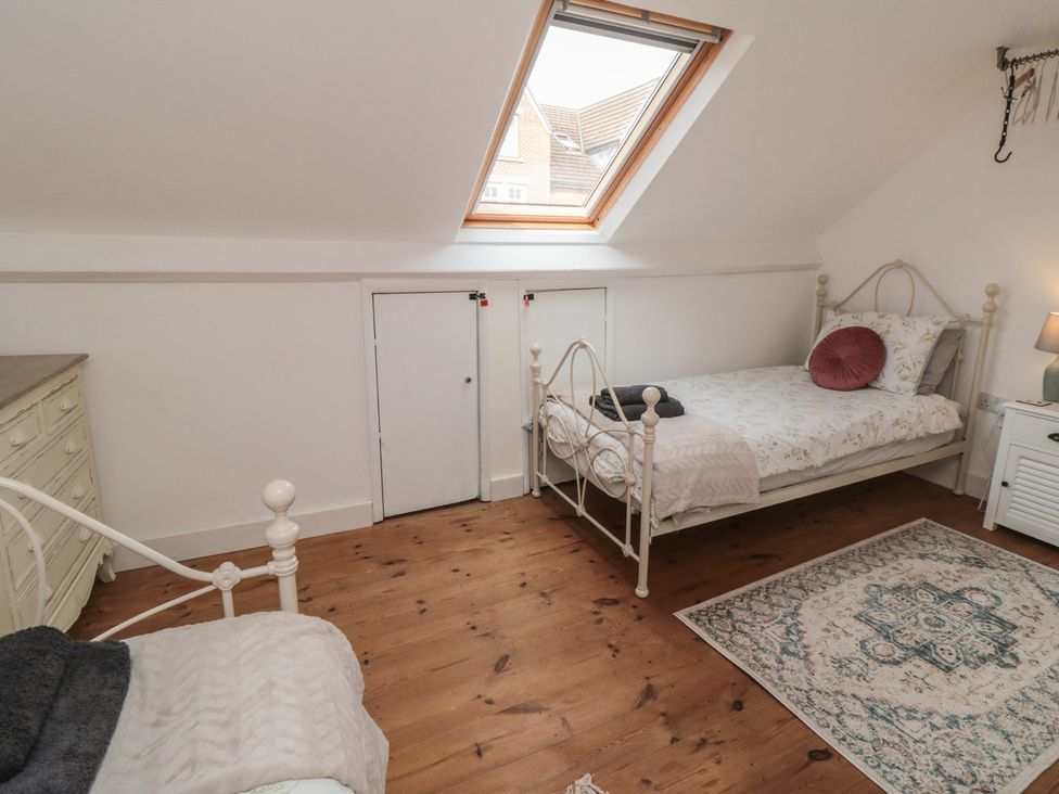 A bedroom with two beds and a wardrobe at 1 Albion Place Whitby