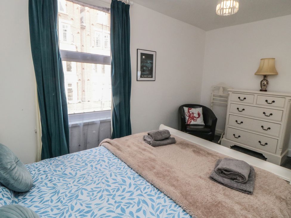 A bedroom with a bed and dressing table at 1 Albion Place in Whitby