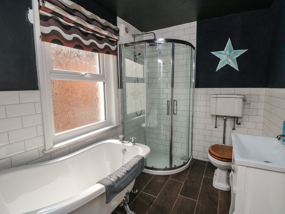 A bathroom with a bathtub, shower, toilet, and sink at 1 Albion Place Whitby