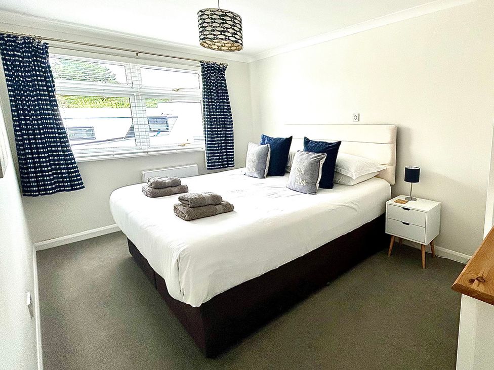 A bedroom with a bed and bedside table at 1 Chatsworth Riverscape Apartments, Newquay