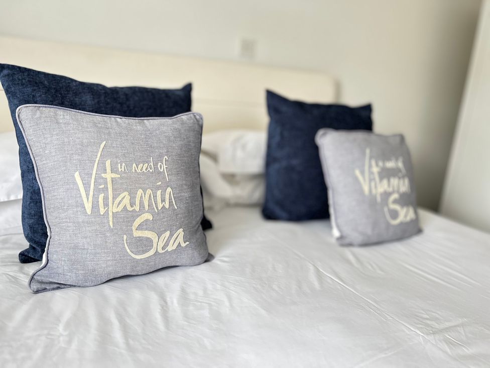 A bed with pillows at 1 Chatsworth Riverscape Apartments Newquay