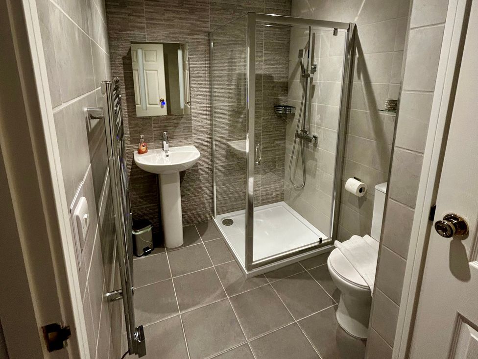 A bathroom featuring a shower, sink, and toilet at 1 Chatsworth Riverscape Apartments in Newquay
