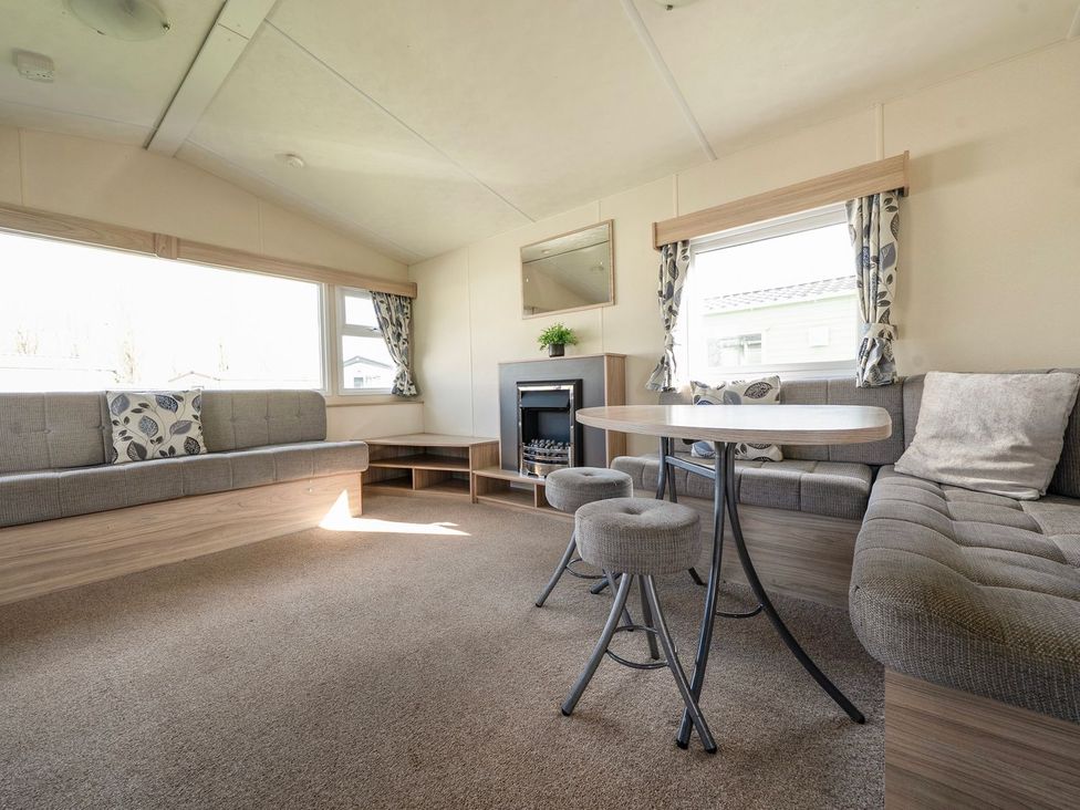 A living room with a sofa and table at Windsurfer’s Rest - Hayling Island