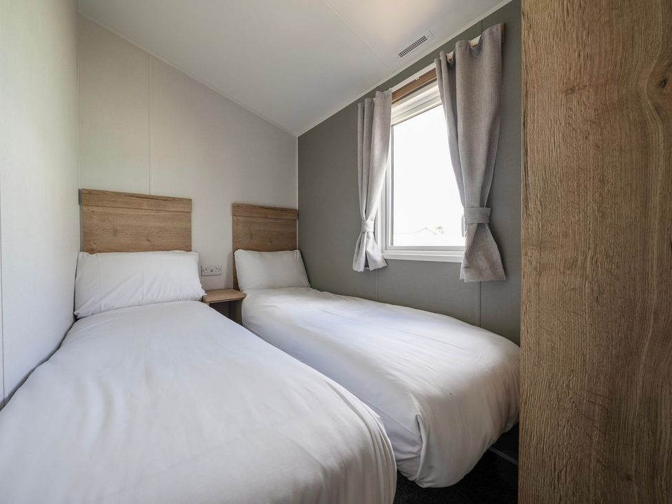 A bedroom with two single beds and a window at Billy’s Way - Hayling Island