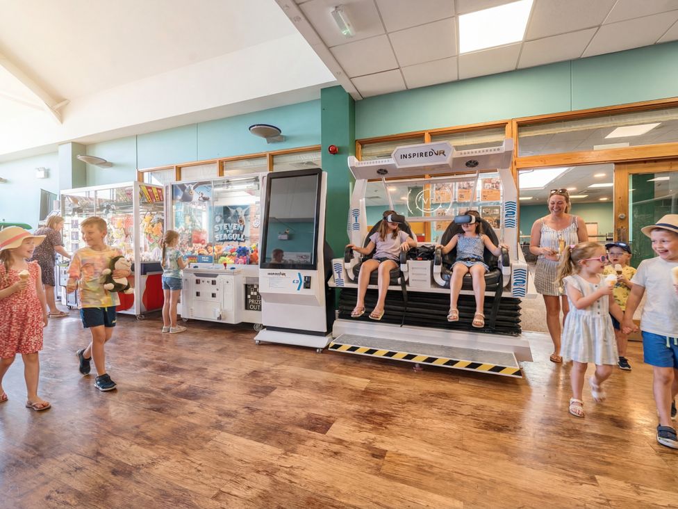 An entertainment area with children and adults engaging with games at Sand and Splash - Hayling Island
